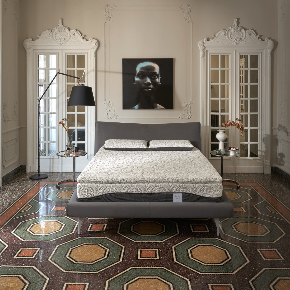 Dorelan ReStyle mattress with a gray bed frame, set in an elegant room with ornate decor and colorful tiled flooring.