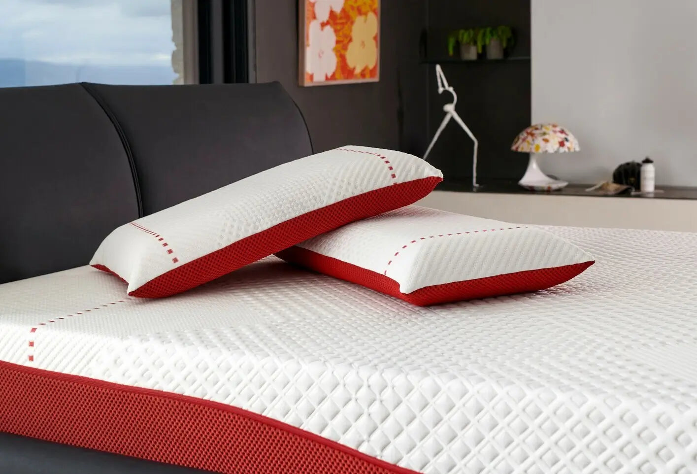 Due cuscini della linea Re:Active di Dorelan posizionati su un materasso coordinato. Il design moderno con dettagli in bianco e rosso si integra perfettamente in un ambiente elegante, simbolo di comfort e stile per un riposo rigenerante